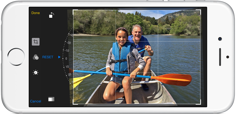 Image of a white iPhone with iOS 8 image editing features shown, rotating and cropping an image of two people in a kayak.