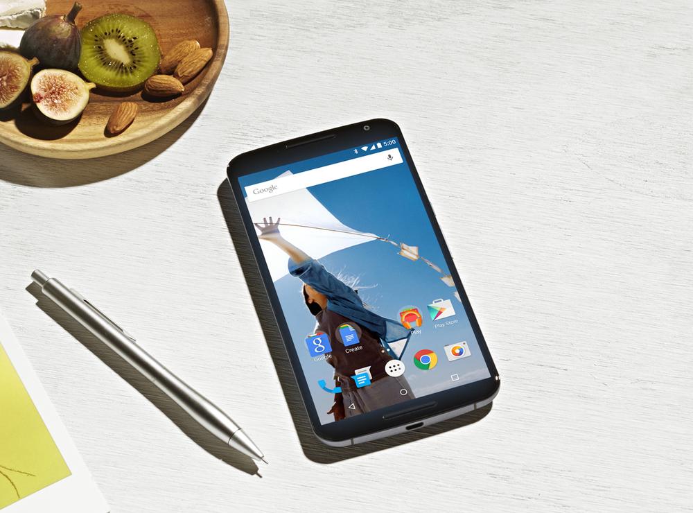 Image of a Nexus 6 device sitting on a table next to a pen, a notepad, and a bowl with kiwi, figs, and almonds.
