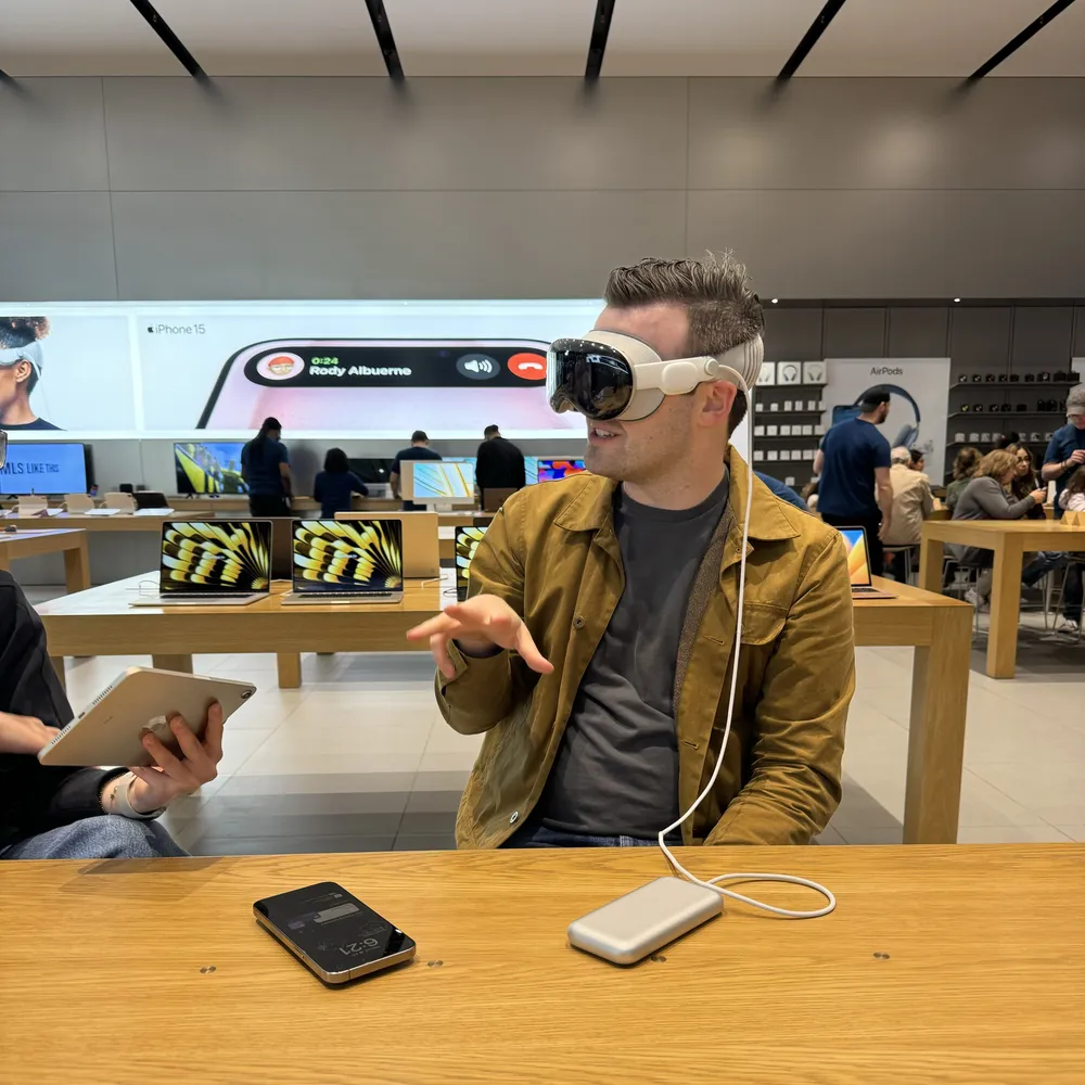 Image of Connor Mason wearing an Apple Vision Pro headset in an Apple Store, talking with his hands.