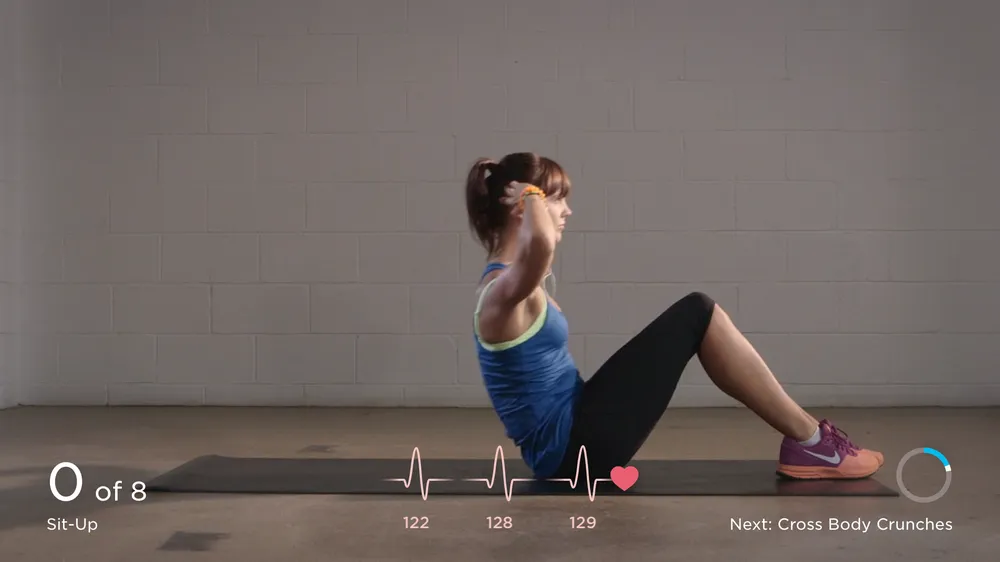 Screenshot of a fitness app, showing a woman doing sit-up exercises on a yoga mat.